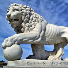 Львы вне дома с лапу на мяч статуя Париж